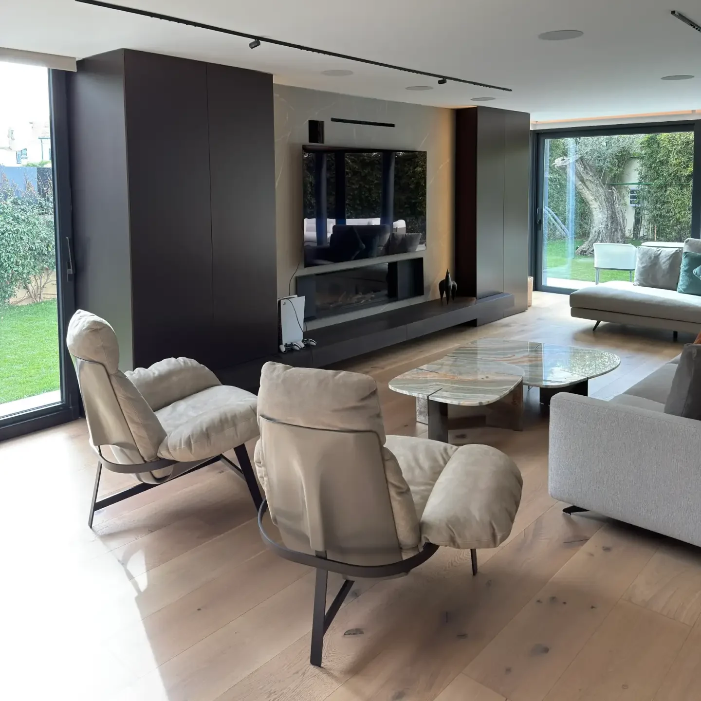Zona de televisión y descanso en salón moderno con iluminación LED empotrada ejecutado por Valandecor.