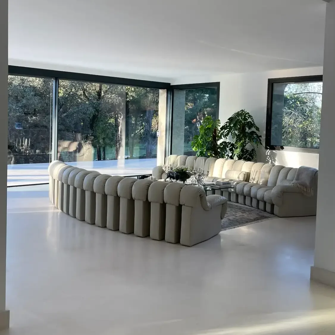 Salón de diseño moderno y grandes ventanales en una vivienda unifamiliar construida en Madrid por Valandecor.