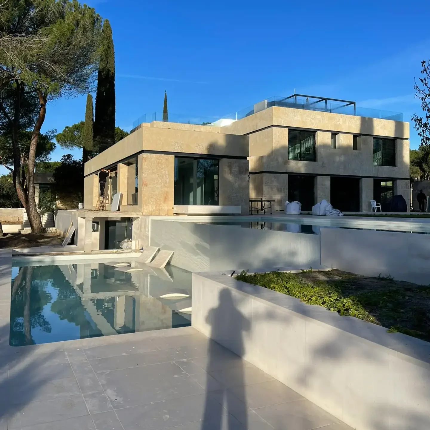 Piscina exterior integrada en el diseño de paisajismo de un chalet de lujo rehabilitado por Valandecor.