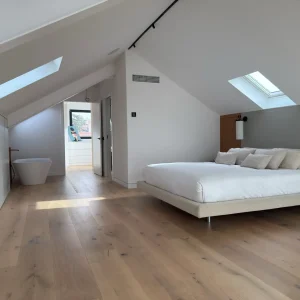 Habitación principal de diseño moderno en ático abuhardillado reformada integralmente en Madrid.