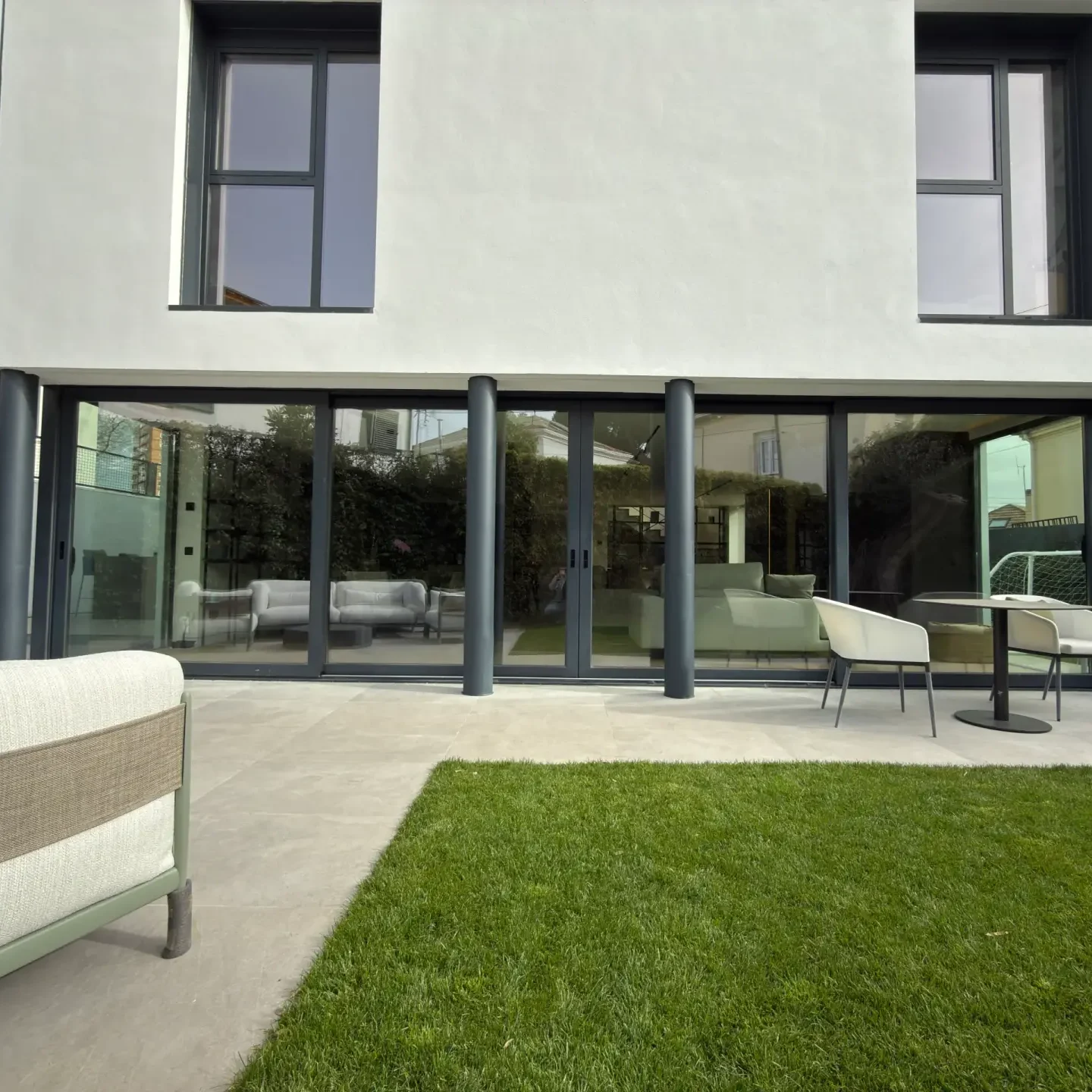 Fachada moderna de chalet unifamiliar con grandes ventanales reformado integralmente por Valandecor en Madrid.