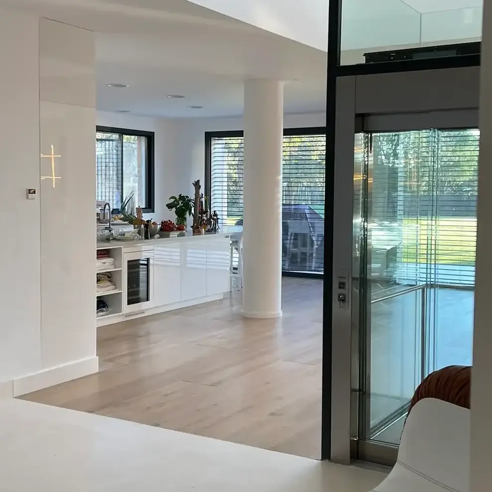 Espacio interior luminoso con lucernarios en el techo y suelo continuo de alta gama que conecta con la cocina.