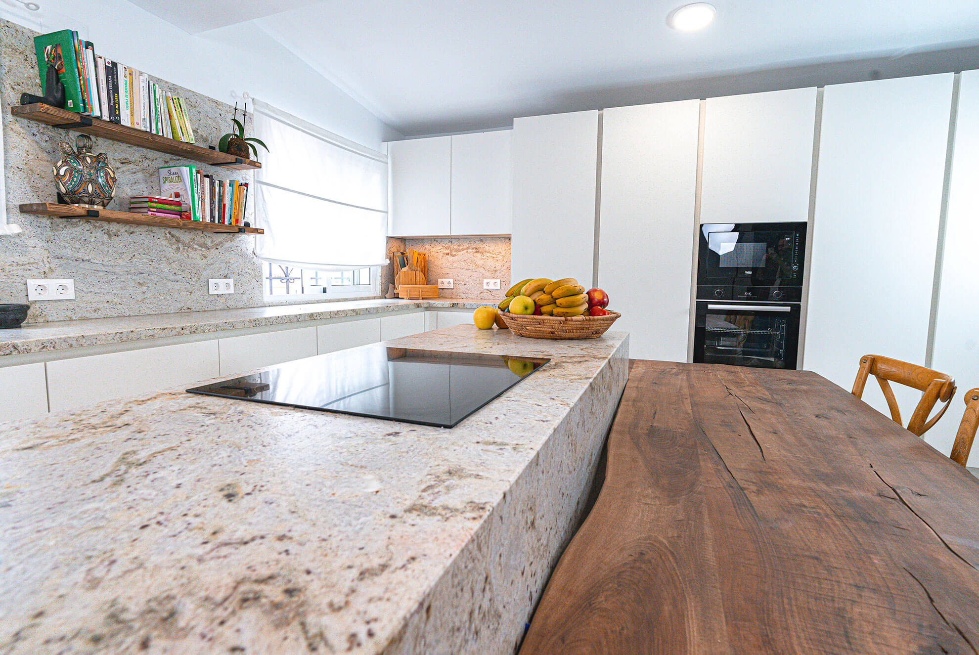 Bancada de cocina en granito natural con vetas continuas y encimera de cuarzo en Madrid