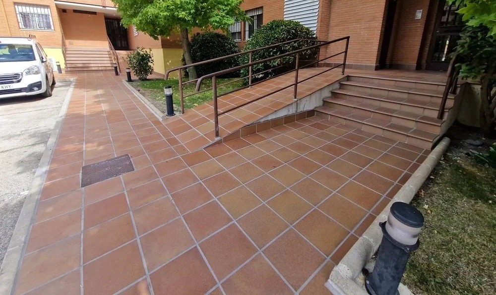 Construcción de rampa accesible con pavimento antideslizante en urbanización de Madrid