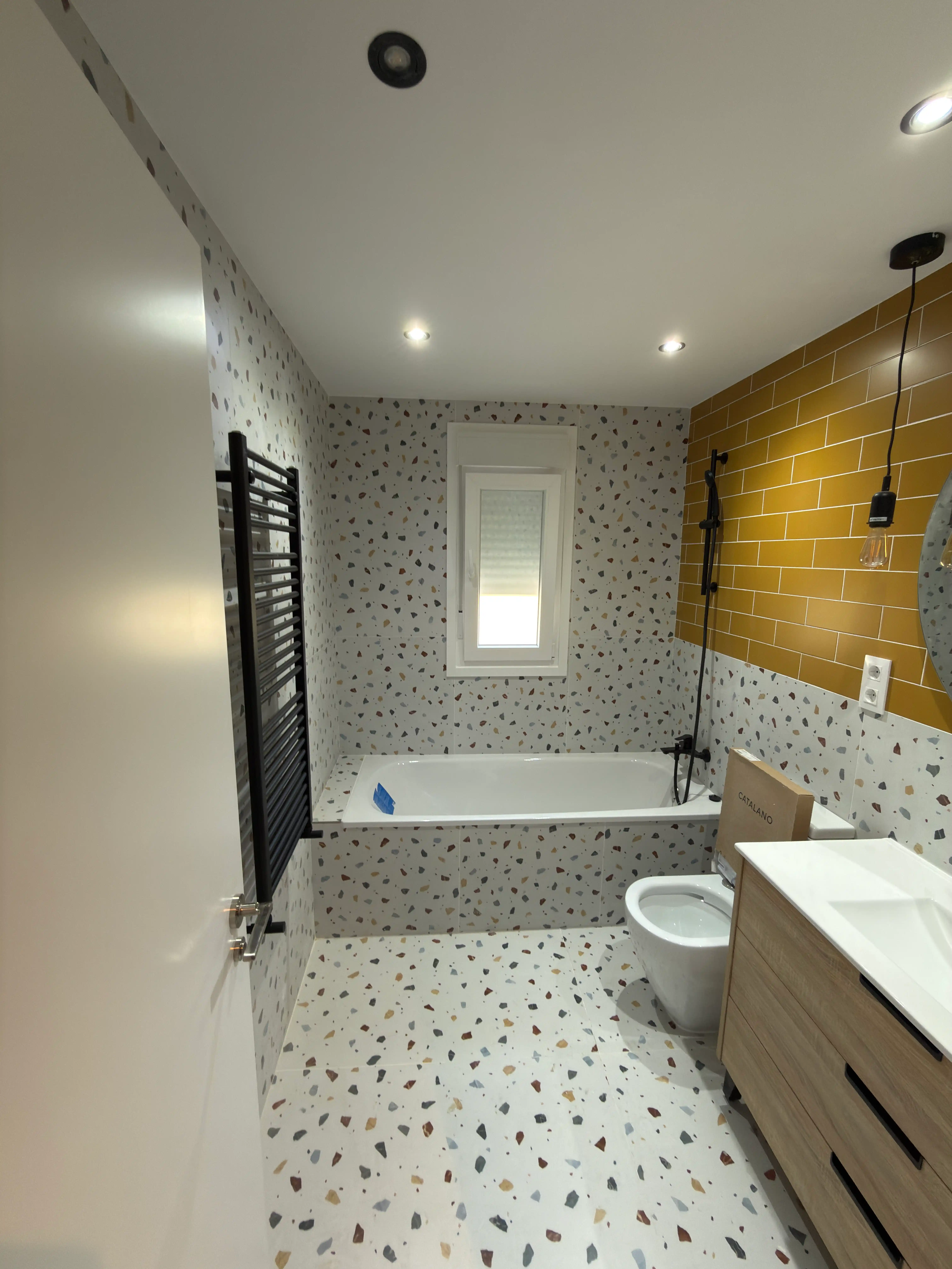 Cuarto de baño de lujo con bañera, detalles en madera y pavimento cerámico decorativo.