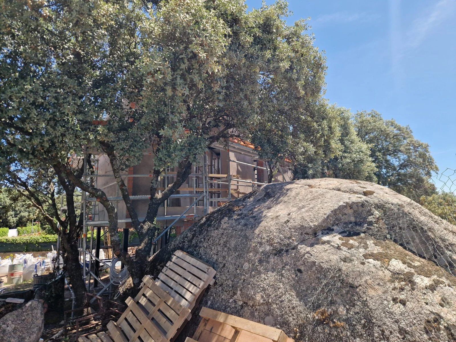 Detalle constructivo de la cimentación de un chalet adaptándose a los afloramientos naturales de granito en la parcela.