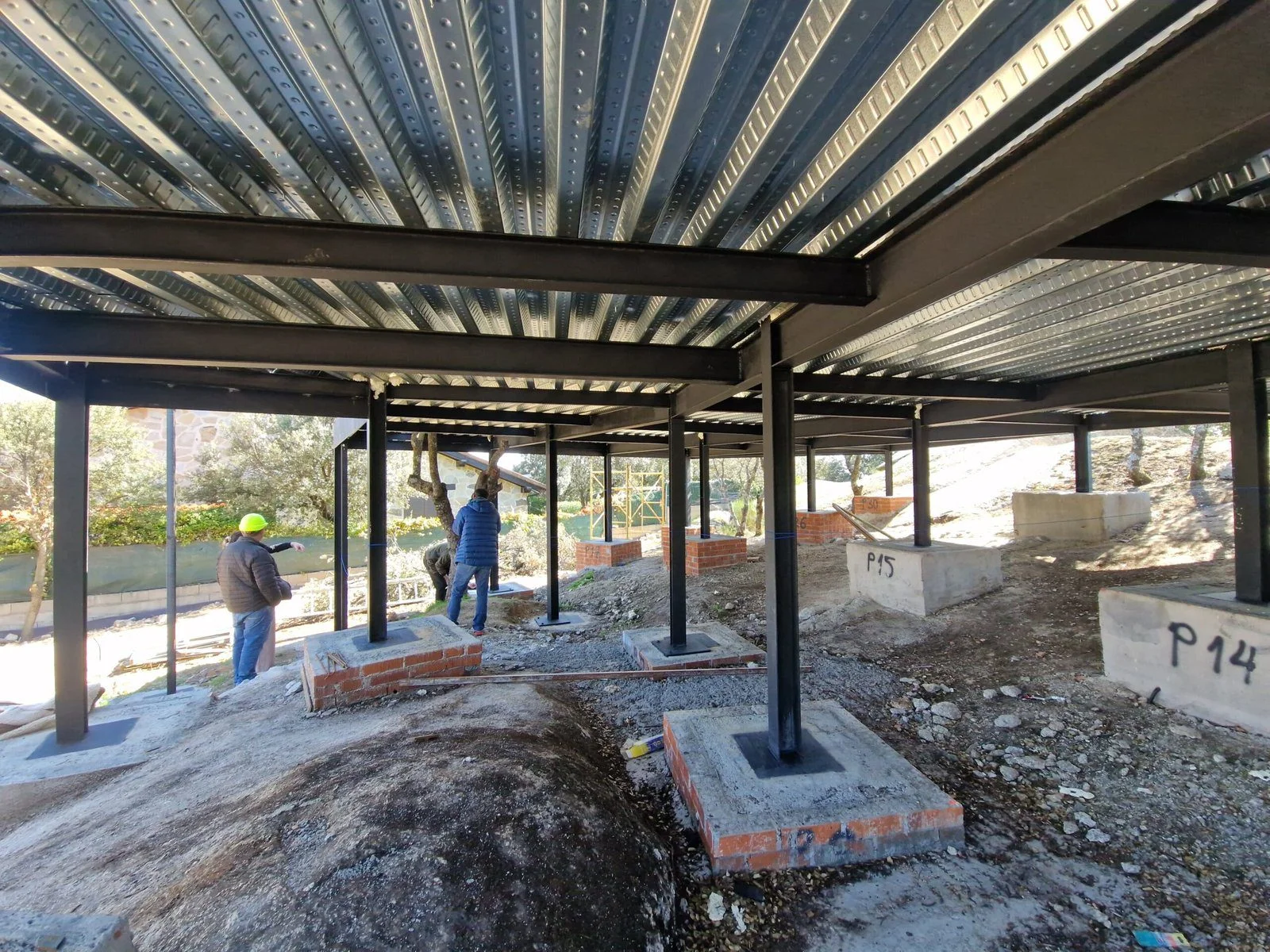 Vista inferior del forjado colaborante y los pilares metálicos que elevan la vivienda para salvar desniveles.