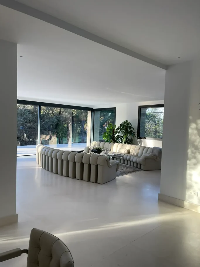 Interiorismo de Salón Moderno de Gran Formato Amplio salón moderno ebanistería a medida e iluminación integrada en chalet reformado en Madrid.